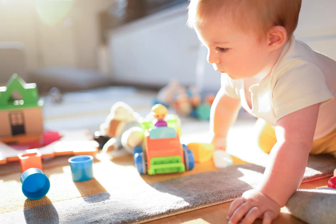 Baby boy playing with his toys on the floor